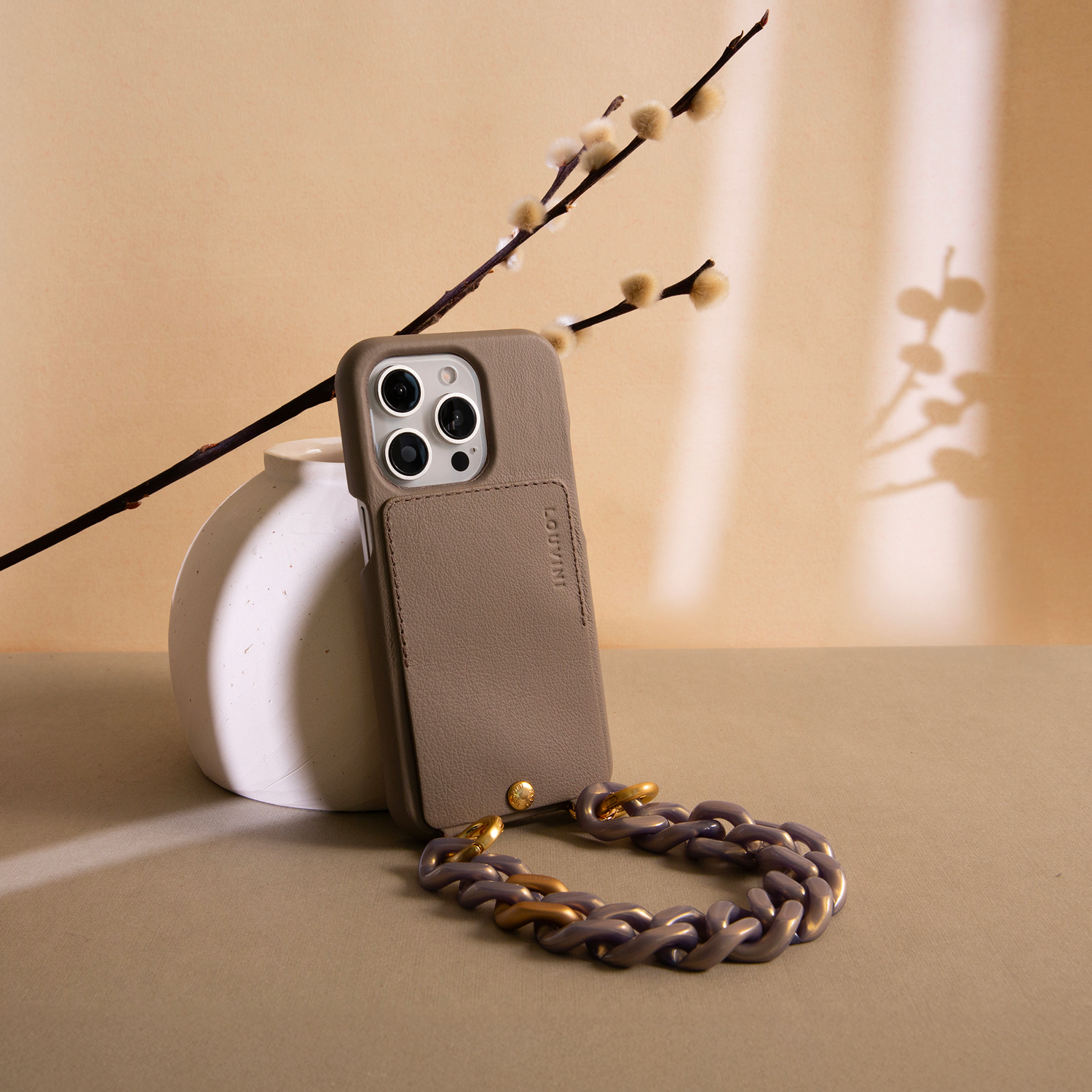 bracelet de téléphone gris doré avec anneaux et coque de téléphone en cuir beige taupe avec porte carte intégré