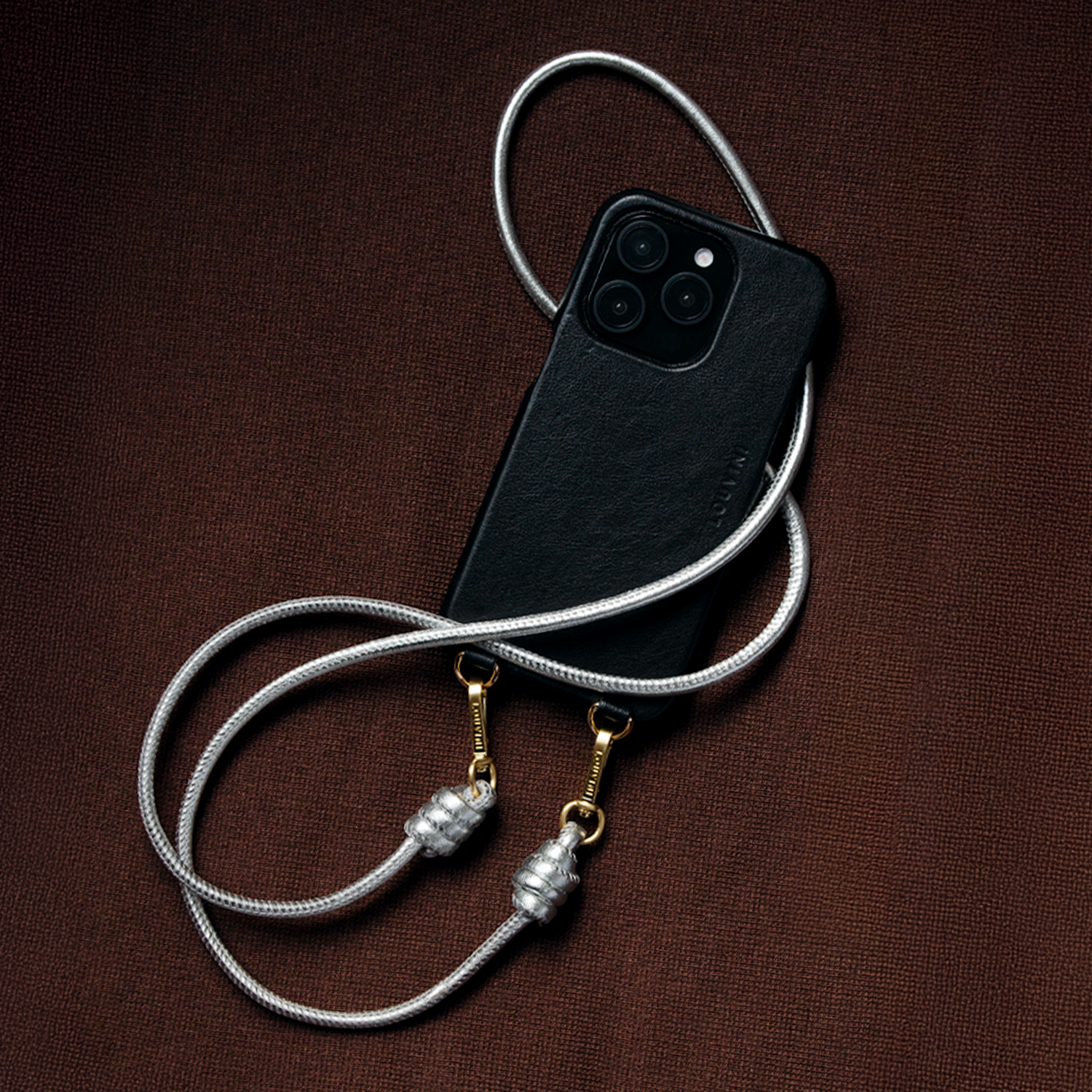 cordon de téléphone bandoulière en cuir argenté avec mousquetons dorés et coque en cuir noir