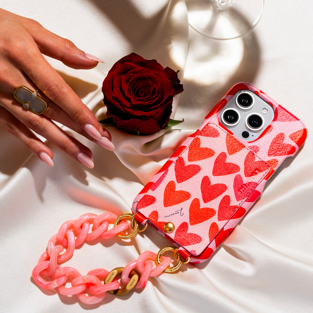coque iphone en cuir imprimé coeurs rose rouge et bracelet de téléphone chaine à maillons rose