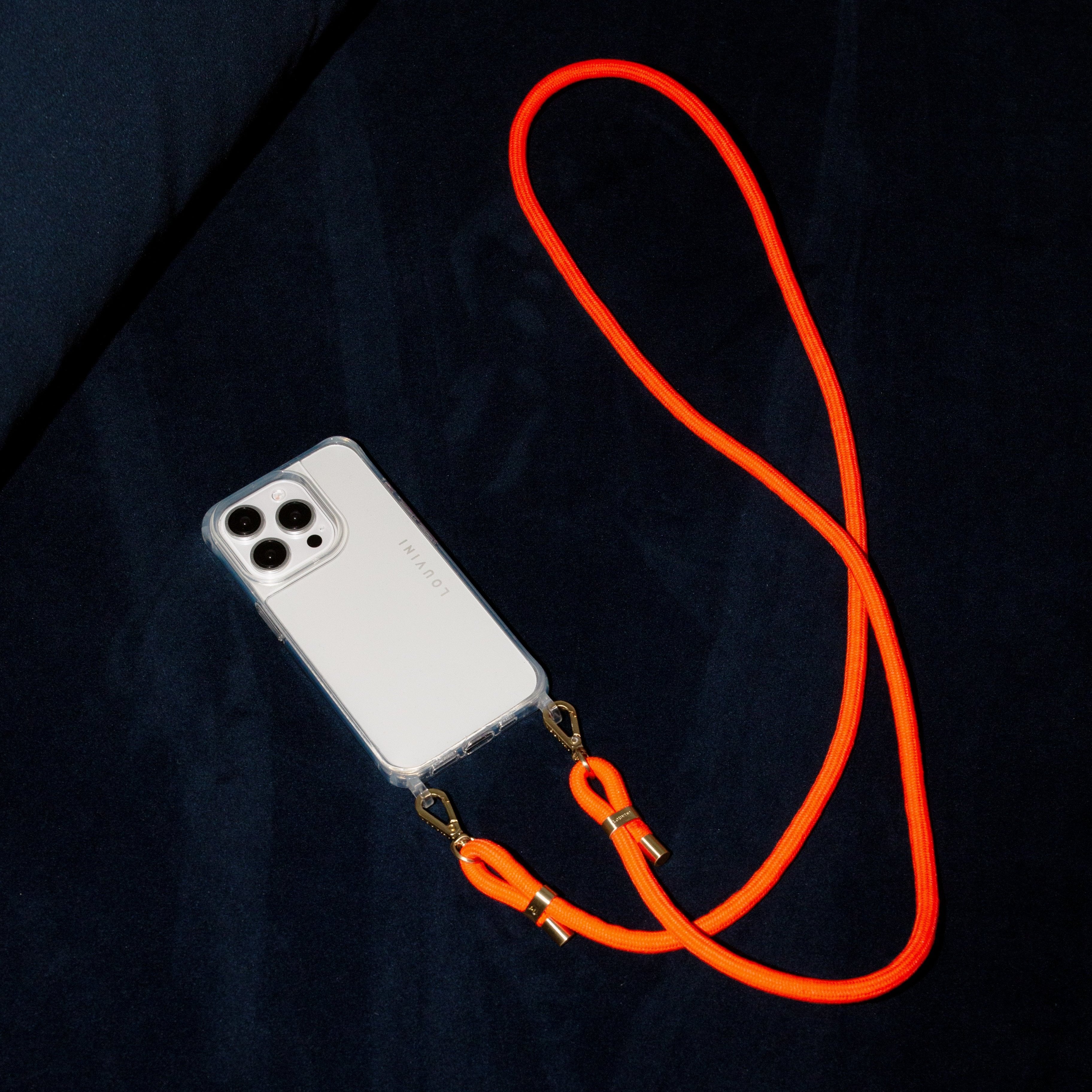 Cordon ajustable pour téléphone orange fluo posé sur canapé