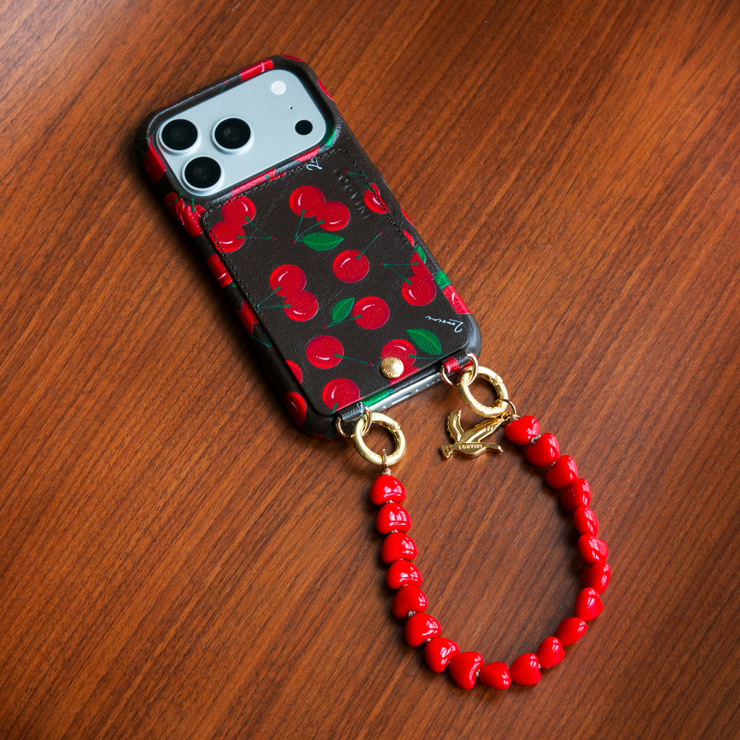 coque iphone en cuir imprimé cerises et bracelet de téléphone à perles petit coeurs rouges