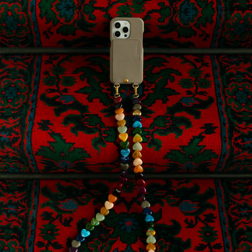 coque iphone beige taupe en cuir avec porte-carte intégré et bandoulière de téléphone à perles coeurs multicolores